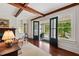 Living room featuring exposed beams, French doors to porch, and fireplace at 118 Duncansby Ct, Cary, NC 27511