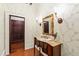 Powder room featuring an antique vanity, floral wallpaper, and sconce lighting at 118 Duncansby Ct, Cary, NC 27511