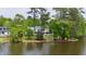 Picturesque waterfront home surrounded by mature trees and a sprawling lawn, offering serene lake views at 118 Duncansby Ct, Cary, NC 27511