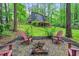 Secluded backyard with fire pit and Adirondack chairs, set against a backdrop of lush greenery and a modern home at 121 Ladybug Ln, Chapel Hill, NC 27516