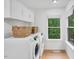 Bright laundry room featuring modern appliances, cabinets, and a large window at 121 Ladybug Ln, Chapel Hill, NC 27516