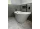 Elegant bathroom featuring a modern soaking tub, stylish fixtures, and marble floors at 123-125 Ottawa Dr., Louisburg, NC 27549