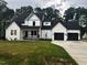 Beautiful two-story home featuring a black roof, white paint, and an attached two car garage at 123-125 Ottawa Dr., Louisburg, NC 27549