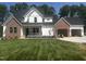 Charming two-story home with brick accents, a black roof, a two-car garage, and a freshly cut green lawn at 123-125 Ottawa Dr., Louisburg, NC 27549