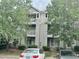 Condo exterior featuring multiple balconies, neutral siding, and mature trees in a residential neighborhood at 1321 Crab Orchard Drive # 203, Raleigh, NC 27606