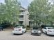 Multi-level condo building featuring multiple balconies with gray siding and mature trees at 1321 Crab Orchard Drive # 203, Raleigh, NC 27606