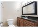 Cozy bathroom featuring a wood cabinet, black countertop, and stylish mirror at 1504 Oak Tree Dr, Chapel Hill, NC 27517