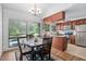Sunny dining area with large window, chandelier, and view of the kitchen at 1504 Oak Tree Dr, Chapel Hill, NC 27517