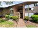 A charming two-story townhome with brown siding, brick accents, and a well-maintained landscaped yard at 1504 Oak Tree Dr, Chapel Hill, NC 27517