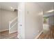 Hallway with wood floors, stairway with white railing, closet, and a slider door leading to the patio at 1903 Malone Rd # E, Burlington, NC 27215