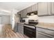 Modern kitchen with gray cabinets, stainless steel appliances, laminate countertops, and vinyl flooring at 1903 Malone Rd # E, Burlington, NC 27215