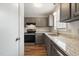 Bright kitchen featuring gray cabinets, stainless steel appliances, granite countertops, and wood-look flooring at 1903 Malone Rd # E, Burlington, NC 27215