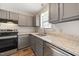 Well-lit kitchen with gray cabinets, modern stainless steel appliances, granite countertops, and wood-look floors at 1903 Malone Rd # E, Burlington, NC 27215