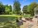 Spacious backyard featuring a stone patio with fire pit and landscaped garden area at 1911 Housatonic Ct, Apex, NC 27523