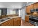 Well-lit kitchen boasts granite countertops, stainless steel appliances, and wood flooring at 1911 Housatonic Ct, Apex, NC 27523
