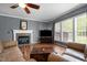 Cozy living room with a stone fireplace, wooden floors and a large window offering outdoor views at 1911 Housatonic Ct, Apex, NC 27523