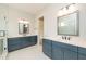 Well-lit bathroom with double vanities, white tile floor, and framed mirrors above at 2 Deer Run Trl, Hillsborough, NC 27278
