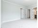 A bright bedroom with neutral carpet, white trim, and multiple doors leading to other rooms at 2 Deer Run Trl, Hillsborough, NC 27278