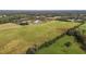 Spacious land dotted with hay bales near a lush tree line and serene pond for picturesque country living at 2 Deer Run Trl, Hillsborough, NC 27278