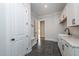 Convenient mudroom with built-in storage, cabinets, granite countertops, and dark tile flooring at 2 Deer Run Trl, Hillsborough, NC 27278