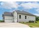 Beautiful home featuring a three-car garage, light gray siding, and well-maintained landscaping at 2 Deer Run Trl, Hillsborough, NC 27278