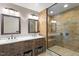 Bathroom featuring a glass-enclosed shower, double sinks, and warm-toned tile at 2008 Elizabeth Ct, Clayton, NC 27520