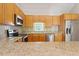 Well-lit kitchen featuring stainless steel appliances, light wood cabinets, and neutral stone countertops at 2008 Elizabeth Ct, Clayton, NC 27520