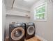 Laundry room with a window and shelving above a washer and dryer set at 2008 Elizabeth Ct, Clayton, NC 27520