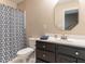 Bathroom features a dark vanity with silver hardware, toilet, and shower with patterned curtain at 204 Highlands Lake Dr. Dr, Cary, NC 27518