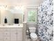Bright bathroom features dual sinks, a neutral shower curtain, a toilet and ample natural light at 204 Highlands Lake Dr. Dr, Cary, NC 27518