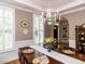 Dining room with a traditional wood table, ornate chandelier, and large windows with shutters at 204 Highlands Lake Dr. Dr, Cary, NC 27518