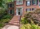 Close-up of red brick front entrance with steps, black railing, and decorative plantings at 204 Highlands Lake Dr. Dr, Cary, NC 27518