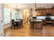 Sunlit eat-in kitchen features hardwood floors, granite countertops, stainless appliances and pendant lighting at 204 Highlands Lake Dr. Dr, Cary, NC 27518