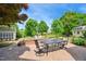 Landscaped backyard with a brick patio, outdoor dining set, and lush greenery, perfect for relaxing and entertaining at 220 Lakecroft Pl, Fuquay Varina, NC 27526