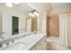 Bright bathroom with double sink, white cabinetry, granite countertop, and shower-tub combo for relaxation at 220 Lakecroft Pl, Fuquay Varina, NC 27526