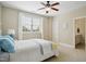 Inviting bedroom featuring a ceiling fan, neutral carpet and walls, with ensuite bathroom for added privacy at 220 Lakecroft Pl, Fuquay Varina, NC 27526
