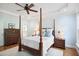Bright primary bedroom with light blue walls, ceiling fan, and a four poster bed with white bedding at 220 Lakecroft Pl, Fuquay Varina, NC 27526