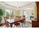 Dining room boasts elegant chandelier lighting, a large window, and beautiful hardwood floors at 220 Lakecroft Pl, Fuquay Varina, NC 27526