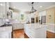 Well-lit kitchen features white cabinetry, stainless steel appliances, a center island, and hardwood flooring at 220 Lakecroft Pl, Fuquay Varina, NC 27526