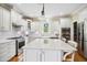 Bright kitchen with white cabinets, an island with a marble countertop, and stainless steel appliances at 220 Lakecroft Pl, Fuquay Varina, NC 27526