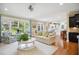 Bright living room with a large window, hardwood floors, and open access to the kitchen area at 220 Lakecroft Pl, Fuquay Varina, NC 27526