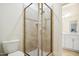 Modern tiled shower with glass doors offering a sleek design and easy access, plus white toilet at 220 Lakecroft Pl, Fuquay Varina, NC 27526