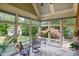Bright sunroom with multiple windows offering serene views of the backyard with a garden shed and vibrant foliage at 220 Lakecroft Pl, Fuquay Varina, NC 27526