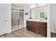Bright bathroom features a glass shower, dual sinks, luxury vinyl flooring and fresh paint at 234 Robert Howe Dr, Fuquay Varina, NC 27526