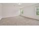 Bright bedroom showcasing plush carpet, two windows and ample lighting at 234 Robert Howe Dr, Fuquay Varina, NC 27526