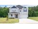 Charming two-story home featuring a covered porch and a two-car garage, nestled on a lush green lawn at 234 Robert Howe Dr, Fuquay Varina, NC 27526