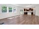 Spacious living room with hardwood floors, large windows, and an open view of the modern kitchen at 234 Robert Howe Dr, Fuquay Varina, NC 27526