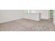 Neutral, carpeted loft area with bright light, electrical outlets, and white walls at 234 Robert Howe Dr, Fuquay Varina, NC 27526