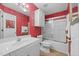 Bathroom with a white vanity, shower-tub combination, and bold red wallpaper at 2424 Cambridge Rd, Burlington, NC 27215