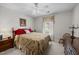 Bedroom with a ceiling fan, a bed with floral bedding, curtains and beige walls at 2424 Cambridge Rd, Burlington, NC 27215